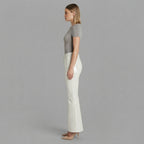 Side profile of women's high waisted white leather flare trousers